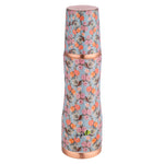 Floral-patterned bottle with copper accents on a white background
